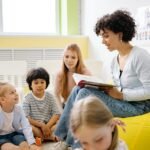 Children sitting with a teacher in a nursery classroom setting