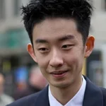 Professional snooker player Wu Yize in a black vest and white shirt, focused during a tournament match.